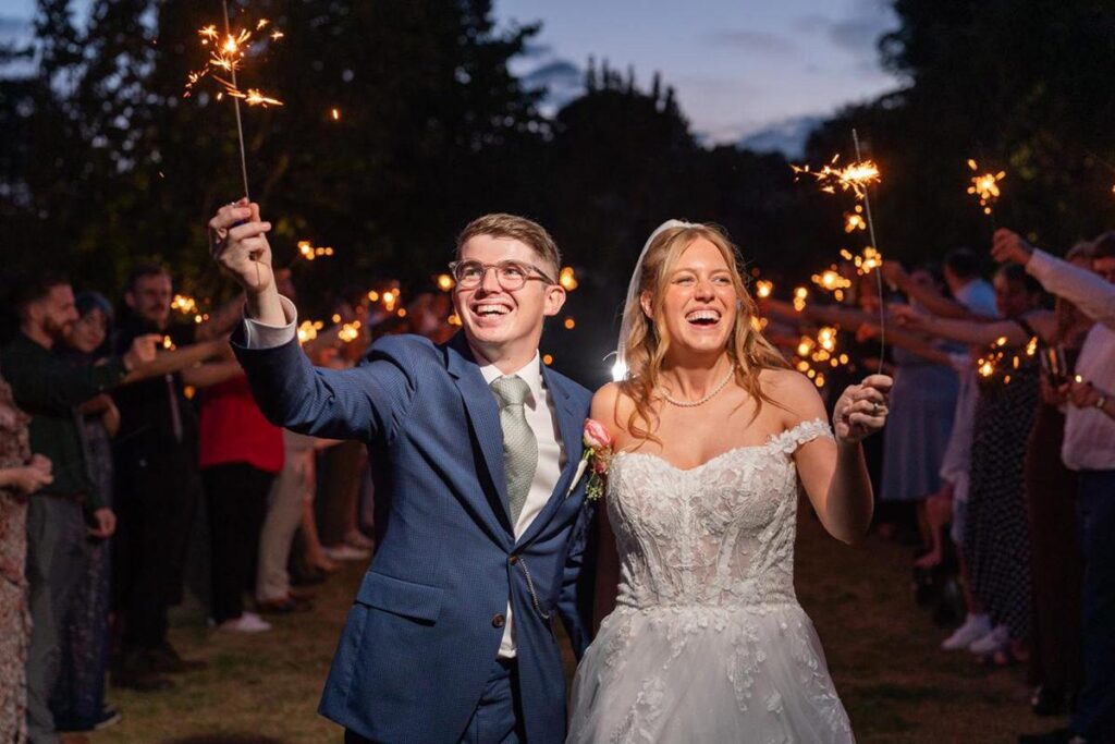 bride and groom with sparklers at dusk