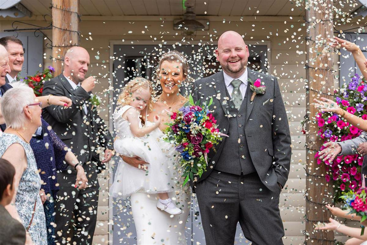 bride and groom walking though confetti